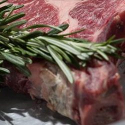 Image of a steak with some herbs on top.